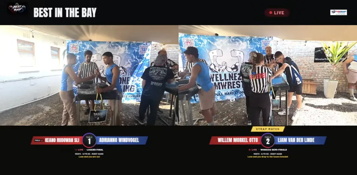 Two tables streaming at the same time at Best in the Bay, side by side, each with its own scoreboard. The right table shows a strap match ribbon.